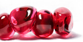 Clustered and sensuous oblong forms in translucent red glass have a smooth polished surface like the fruit that surrounds pomegranate seeds. Image 8
