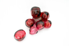 Clustered and sensuous oblong forms in translucent red glass have a smooth polished surface like the fruit that surrounds pomegranate seeds. Image 2