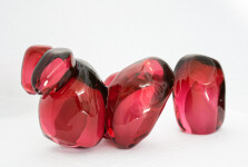 Clustered and sensuous oblong forms in translucent red glass have a smooth polished surface like the fruit that surrounds pomegranate seeds. Image 6