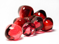 Clustered and sensuous oblong forms in translucent red glass have a smooth polished surface like the fruit that surrounds pomegranate seeds. Image 5
