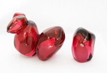 Clustered and sensuous oblong forms in translucent red glass have a smooth polished surface like the fruit that surrounds pomegranate seeds. Image 3