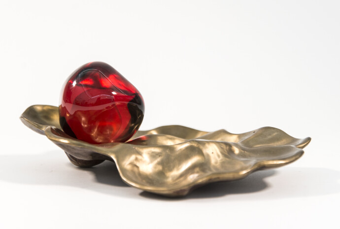 Luscious pomegranate red glass nesting in a bronze casing.