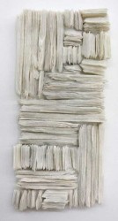 Wafers of cool white glass frit are layered and stacked in a curated wall relief by Cheryl Wilson Smith.