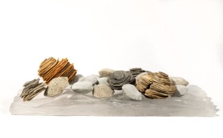 The beauty of a clear, cool stream—the water rippling beneath a bed of rocks is captured in this dynamic tabletop sculpture by Cheryl Wilson…