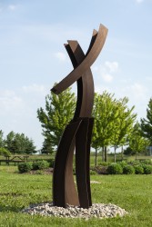 Elegantly curved columns of corten steel appear to float in mid-air in this outdoor sculpture by Claude Millette.