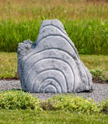 Concentric rings are carved on one side of this triangular chunk of limestone.
