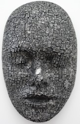 Old metal type welded together to form a large enigmatic mask is cast in aluminum.