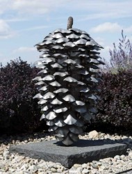 A shiny stainless-steel lodgepole pine cone created by Canadian sculptor Floyd Elzinga glints in the sunlight.