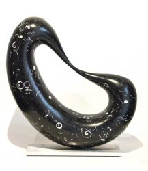 Smooth, black granite flecked with embedded, white sea shells is engineered into an elegant loop in this table top sized sculpture.