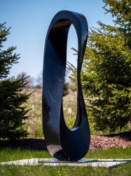 Smooth surfaced, black granite has been engineered by Jeremy Guy into an elegant outdoor sculpture in the form of a mobius strip.
