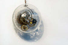 Three blown glass orbs that contain assembled clock works, wheels, sprockets and coils, hang from fine chain in this unique wall sculpture.T… Image 4