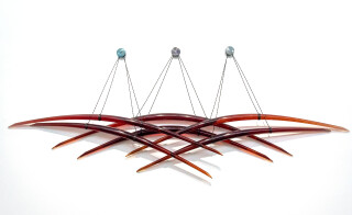 Arcs of glowing crimson glass are curated into elegant overlapping waves in this wall sculpture by John Paul Robinson.