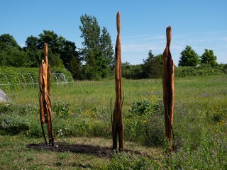 Three totems of cedar driftwood and steel communicate a theme of journey and transformation in this installation by Liz Rae Dalton.
