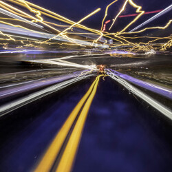 Shocks of light -- yellow , indigo, red and white -- zip through the night in this dynamic photographic print by Mark Bartkiw.
