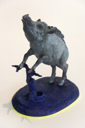 Cast in resin, a figurine of a boar posed on an indigo base points to a theme of human and animal interaction that includes taxidermy.