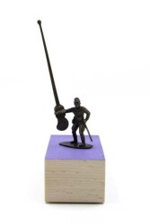 A military figure challenges an invisible foe with a latte stick in this playful bronze sculpture with wood base by P.