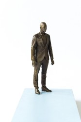 A suited man stands poised, staring intently in this intriguing psychological narrative in bronze by sculptor P.