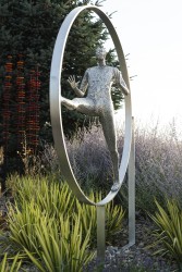 In this spirited sculpture by Paul Duval, a single almost life-sized figure appears to be walking inside a large aluminum ring.