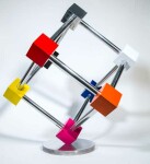 In this dynamic sculpture by Phillipe Pallafray, an open 3D stainless steel cube; each point connected by a brightly coloured solid cube in … Image 6