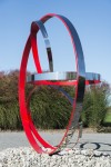 Four stainless steel rings, one side in poppy red, are curated into a elegant outdoor composition by Philippe Pallafray. Image 3