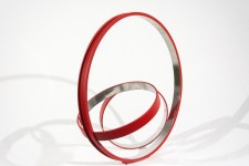 Three stainless steel rings, polished on the inside and a matte cardinal red on the exterior, are curated into an elegant, minimalist compos… Image 3