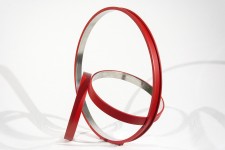 Three stainless steel rings, polished on the inside and a matte cardinal red on the exterior, are curated into an elegant, minimalist compos… Image 8