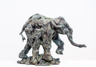 This delightful bronze statuette of a walking baby elephant is highly textured and finished with an elegant sepia patina.