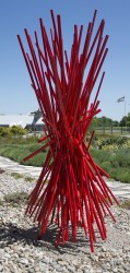 Bold, contemporary steel welded abstract construction is painted with a vibrant red finish, which catches and reflects the light.