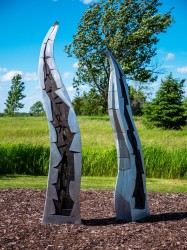 Two shoots rise from the ground and reach for the sky in this finely crafted aluminum sculpture by Stephane Langlois.