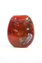 This brilliant merlot red flattened vessel in blown glass takes its organic shape and wild patterns from nature.