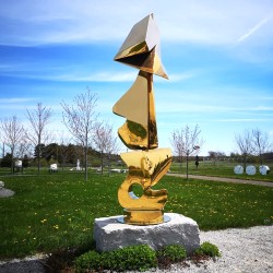 Abstract shapes in gold plated stainless steel are stacked into this playful outdoor column by Viktor Mitic.
