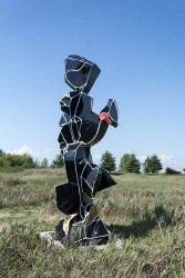 Black, gold and red organic shapes bordered by white lines form a playful column in this outdoor sculpture by Viktor Mitic.