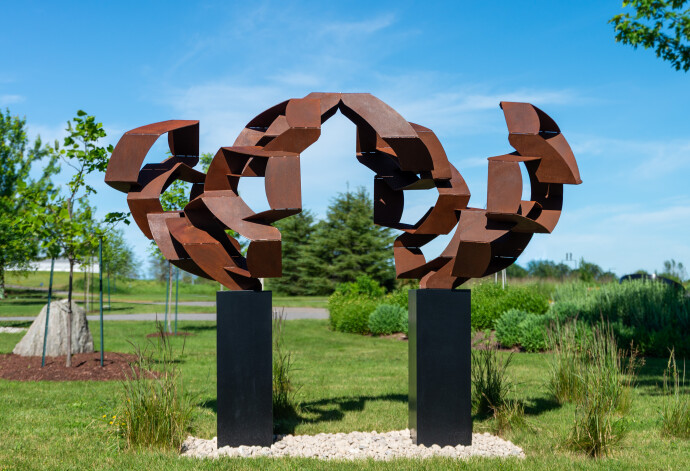 This monumental metal outdoor sculpture is rendered in a contemporary geometric form.