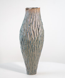 This contemporary tall ceramic vessel is handmade.