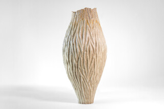 This unique tall ceramic vessel is handmade.