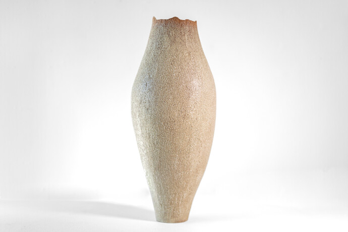 This unique tall ceramic vessel is handmade.