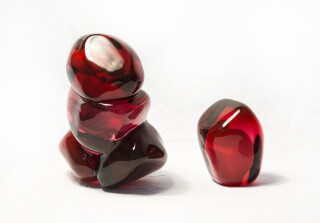 A grouping of luscious pomegranate red glass and one single seed.