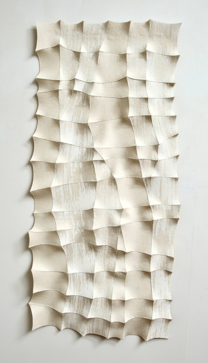 This contemporary white sculptural wall hanging was handmade.
