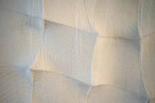 In this elegant monochromatic white tapestry by fabric artist Chung-Im Kim, finely detailed patterns swirl around the fabric. Image 6