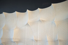 In this elegant monochromatic white tapestry by fabric artist Chung-Im Kim, finely detailed patterns swirl around the fabric. Image 9