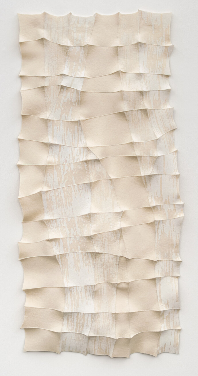 This contemporary white sculptural wall hanging was handmade.