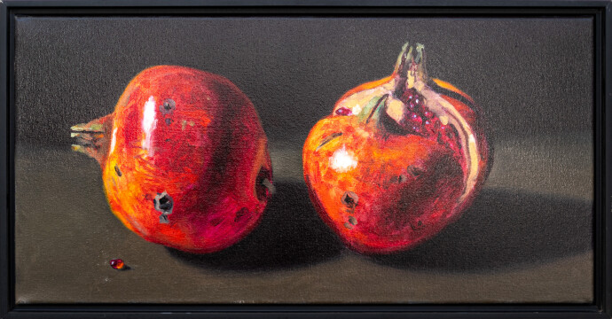 Two red-orange pomegranates, one cut cleanly in half are set on a dark ground in this realistically rendered and intimate oil painting on ca…