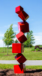 This outdoor contemporary geometric metal sculpture is made of red cubes. Image 3