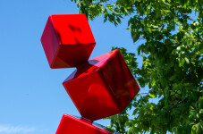 This outdoor contemporary geometric metal sculpture is made of red cubes. Image 8