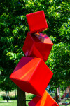 This outdoor contemporary geometric metal sculpture is made of red cubes. Image 6