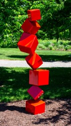 This outdoor contemporary geometric metal sculpture is made of red cubes.