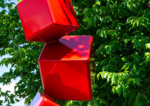 This outdoor contemporary geometric metal sculpture is made of red cubes. Image 7