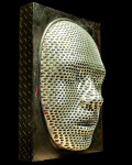 This contemporary figurative wall sculpture is a mask forged from metal lit with LED light. Image 4