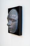 This contemporary figurative wall sculpture is a mask forged from metal lit with LED light. Image 3
