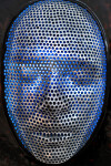 This contemporary figurative wall sculpture is a mask forged from metal lit with LED light. Image 6